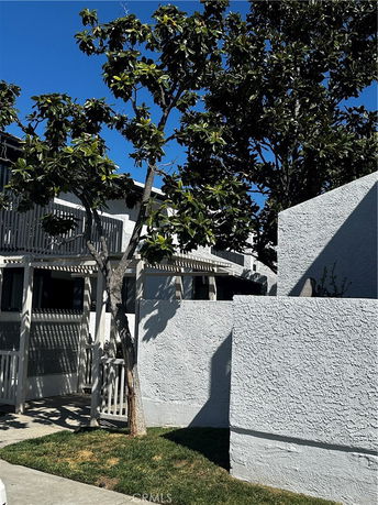 Front view of a building with white walls and surrounding trees.