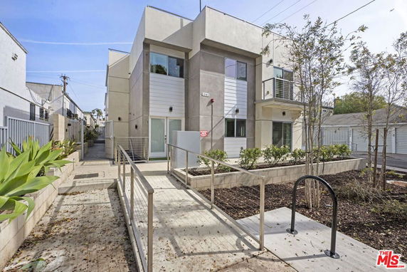 Front view of a modern two-story building with large windows and a small balcony.