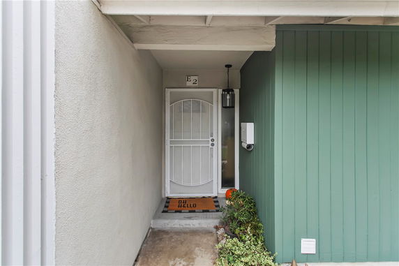 Front entrance of a house with a white security door and green siding.