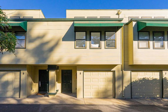 Front view of a two-story building with multiple garages and a flat roof.