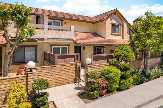 Front view of a two-story house with a tiled roof and balconies.