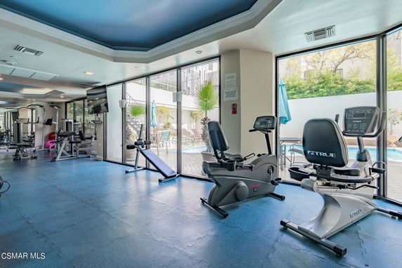 Interior view of a gym with exercise equipment and large windows.