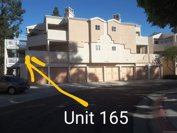 Front view of a multi-story apartment building with multiple garages.