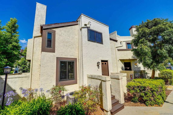 Front view of a two-story house with a textured finish and multiple windows.