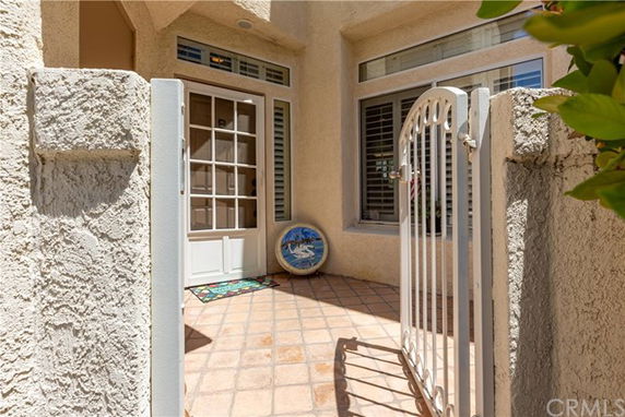 Front entrance of a house with a French door and a small gated courtyard.