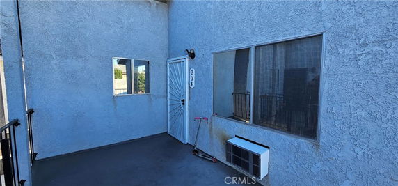 Exterior view of a building entrance with windows and a door marked 204