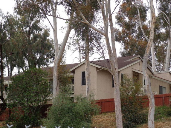 Front view of a single-story house with trees around.