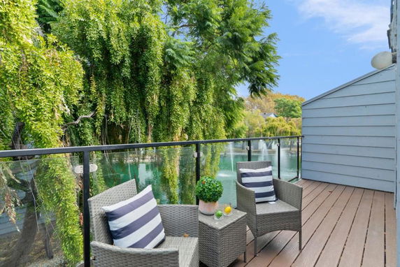Outdoor patio with a view of surrounding trees and a water fountain.