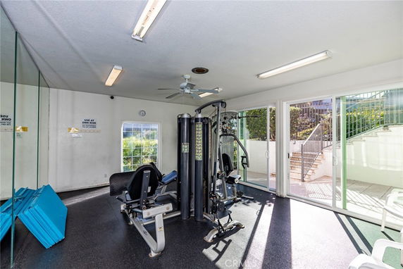 Indoor gym area with exercise equipment and mirrored wall.