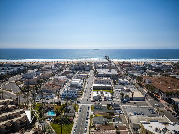 Panoramic view of a coastal town with ocean, beach, and pier visible in the distance.