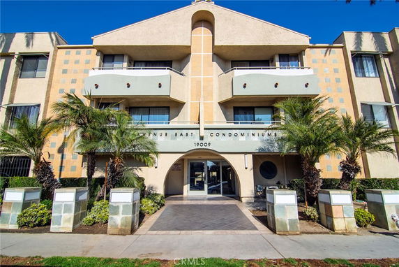 Front view of a multi-story condominium building with balconies.