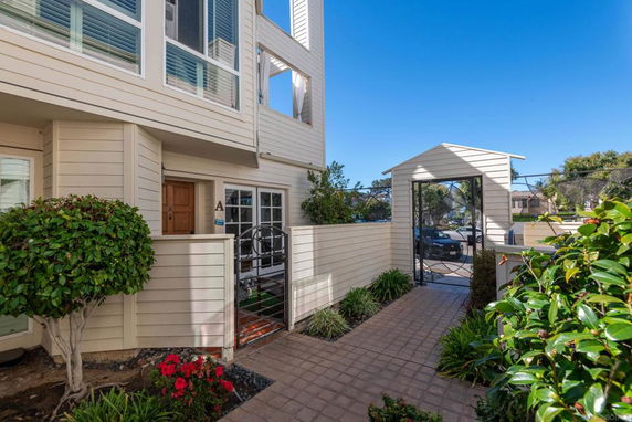 Front view of a multi-story house with a gate and small garden area.