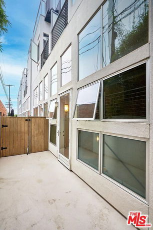 Front view of a multi-story building with large windows and a gated entrance.