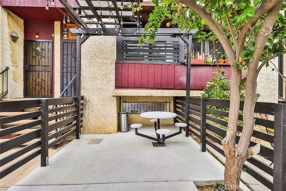 Front view of a house with a red accent wall and an iron gate entrance.