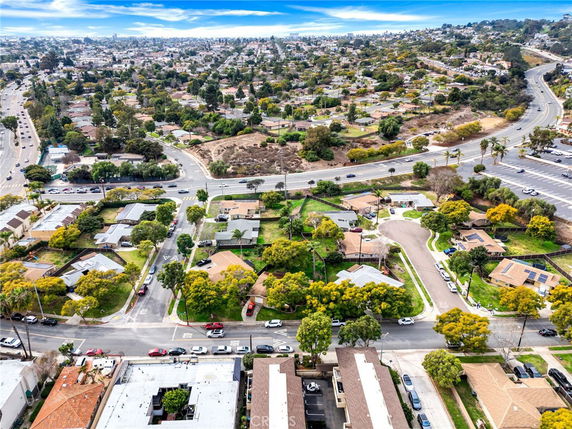 Aerial panoramic view of a suburban area with roads, houses, and greenery.