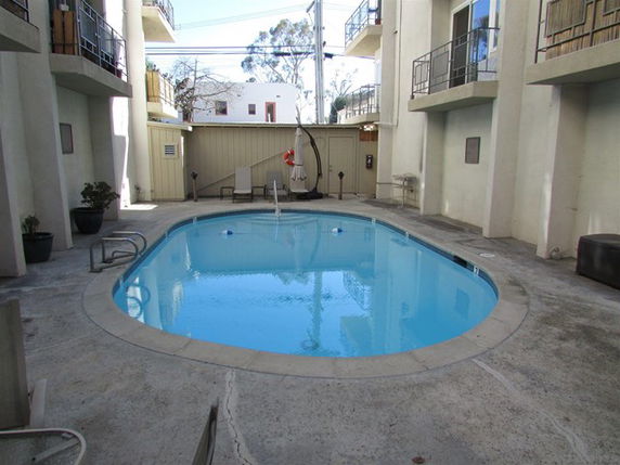 Outdoor swimming pool surrounded by buildings.