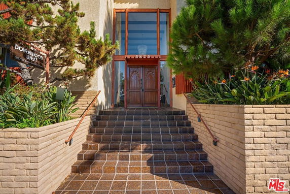 Front view of a building with decorative wooden doors and steps leading up.