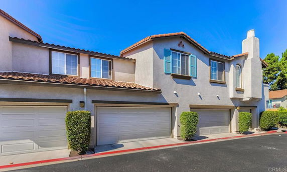 Front view of a two-story townhouse with multiple garages.