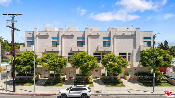 Front view of a row of modern townhouses with balconies and large windows.