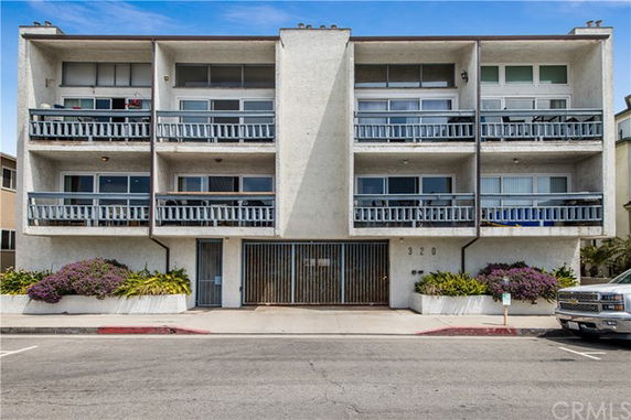 Front view of a three-story apartment building with balconies.
