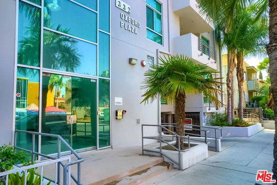 Front view of a modern building with large glass entrance and signage.