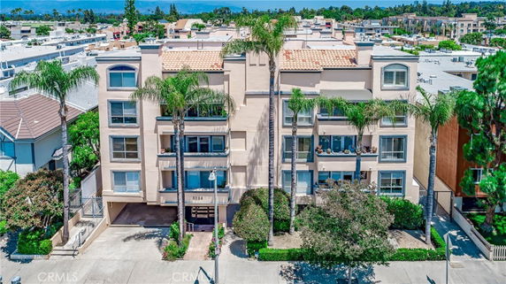 Front view of a multi-story residential building with palm trees.