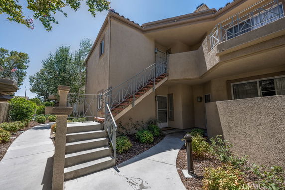 Front view of a two-story apartment building with outdoor stairs leading to the second floor.