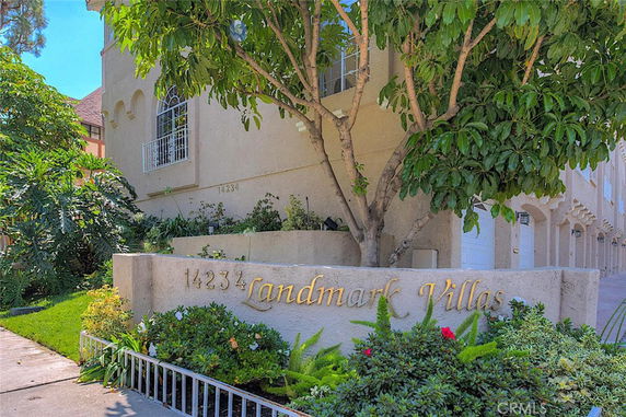 Front view of a multi-story building with a sign reading 'Landmark Villas'.