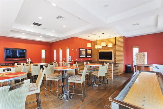 Interior view of a recreational club house area with tables, chairs, and entertainment facilities.