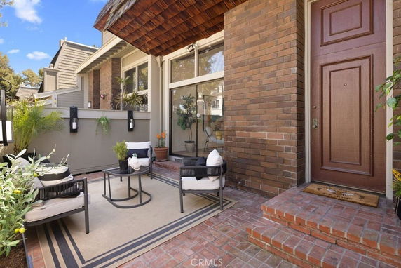 Front view of a house with brick exterior and patio seating area.