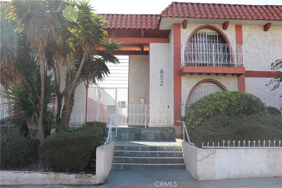 Front view of a two-story house with a tiled roof and balcony.