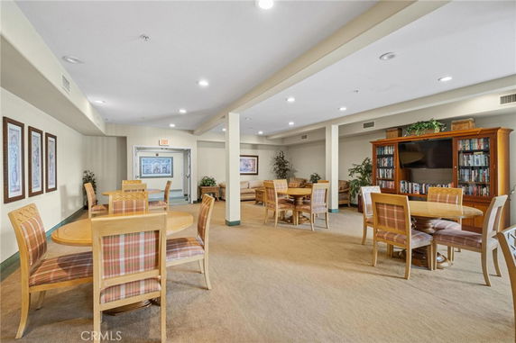 Indoor recreation area with tables, chairs, and bookshelves.