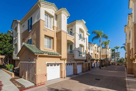Front view of a multi-story apartment building with individual garages.