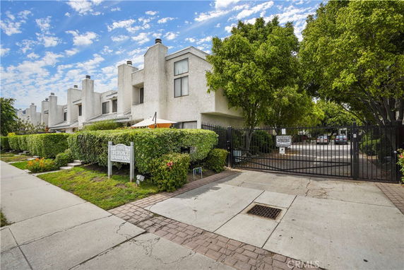 Front view of a multi-story residential complex with gated entrance.