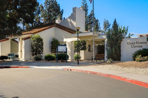 Front view of a building with a covered entrance and signage reading 'Oaks North Center'.