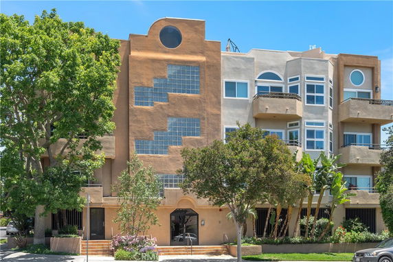 Front view of a multi-story building with a distinctive geometric glass block design and balconies.