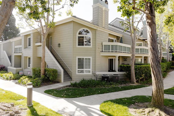 Front view of a multi-story residential building with balconies and exterior stairs.