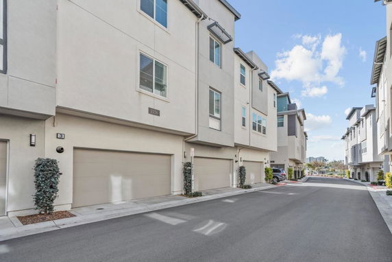 Front view of multi-story townhouses with garages.