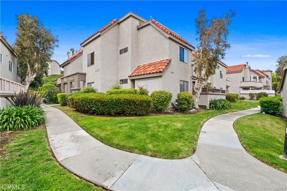 Front view of a two-story house with a tiled roof and stucco exterior.