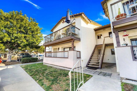 Front view of a two-story house with exterior stairs and balconies.