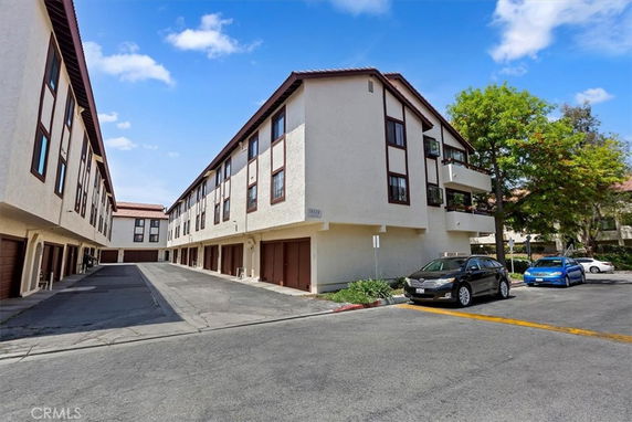 Front view of a multi-story building with garages on the ground floor.