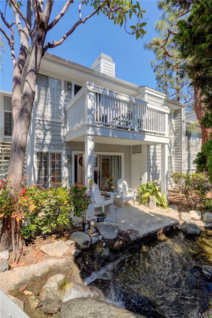 Front view of a two-story house with a balcony and patio.