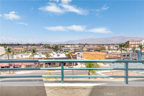 Panoramic view of a city with buildings and mountains in the background.