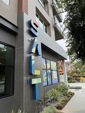 Front view of a building with large colorful letters spelling 'SALT' on the facade.