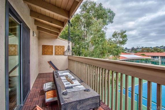 Outdoor balcony view with trees and buildings in the background