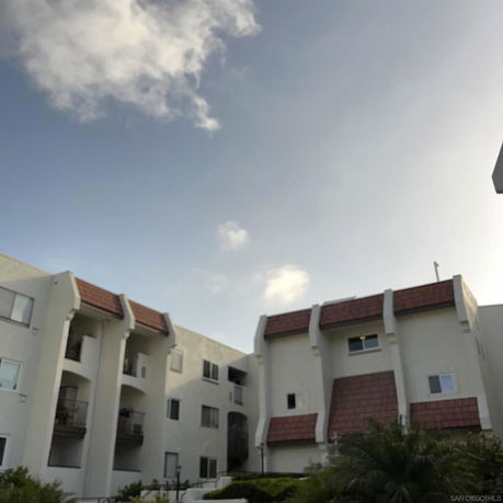 Front view of a multi-story residential building with a sloped roof.