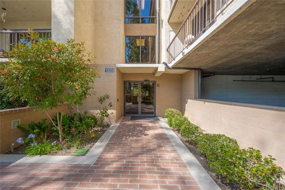 Entrance of a multi-story residential building with a brick pathway.