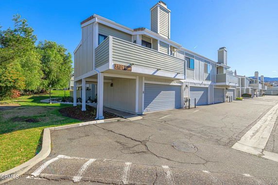 Front view of a multi-story townhouse with garages and balconies.