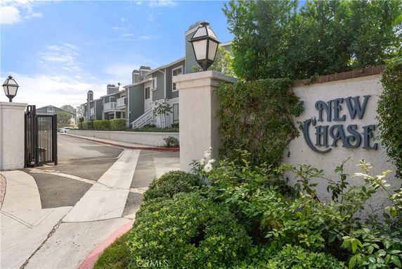 Front view of a multi-story building with gated entrance and sign reading 'New Chase'.