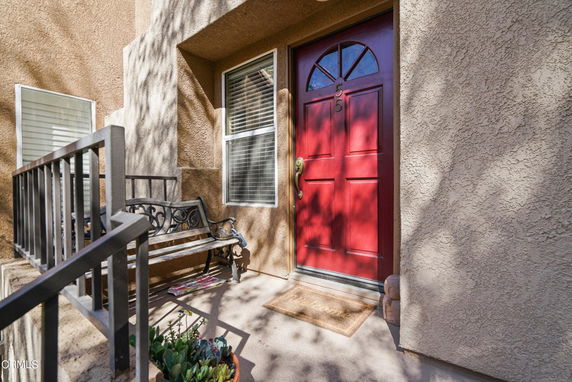 Front view of a house entrance with a red door and small porch.